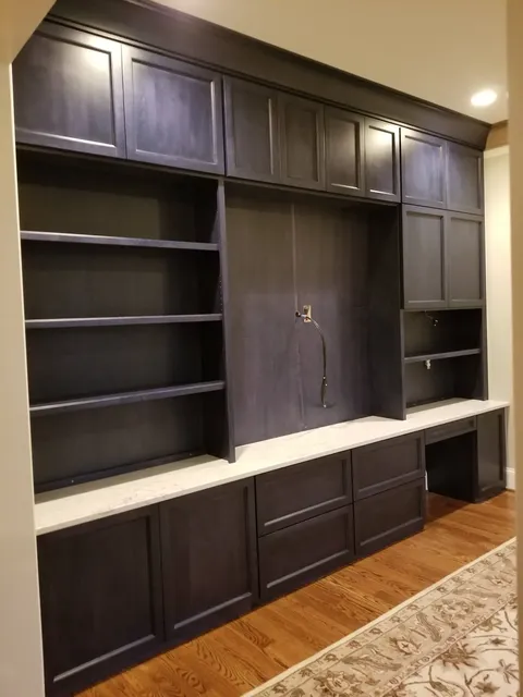 Dark wood built-in cabinetry with open shelving and marble countertop