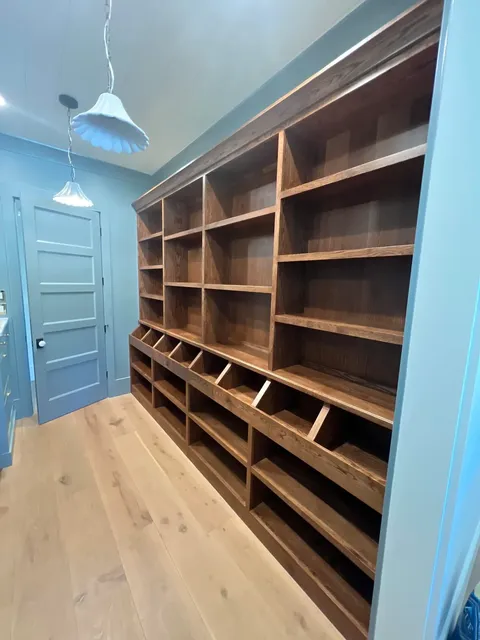 Walnut open shelving in blue room with custom wood construction
