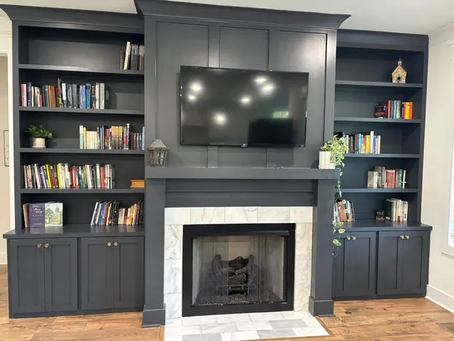 Dark slate fireplace surround with built-in shelving and TV mounting
