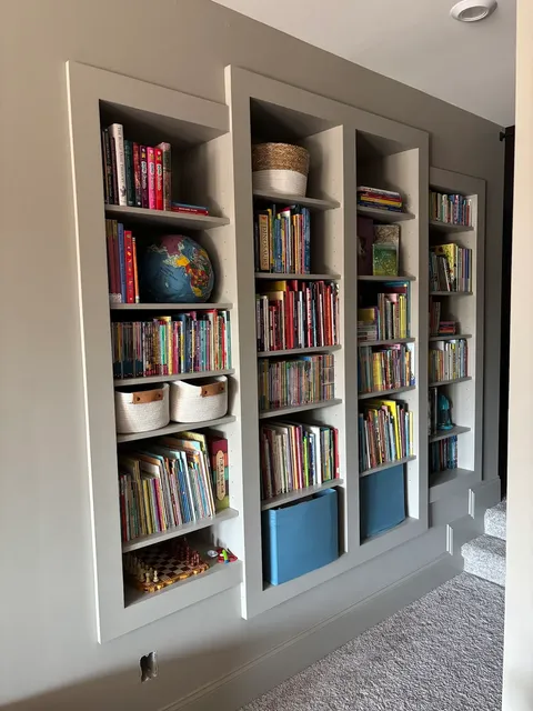 White built-in shelving with storage cubbies and blue accent doors