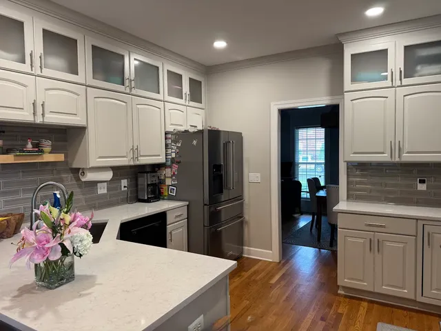 White and gray kitchen with glass-front uppers and quartz countertop
