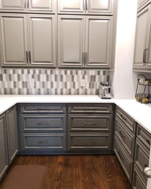 White shaker kitchen cabinetry with checkered backsplash and two-tone island
