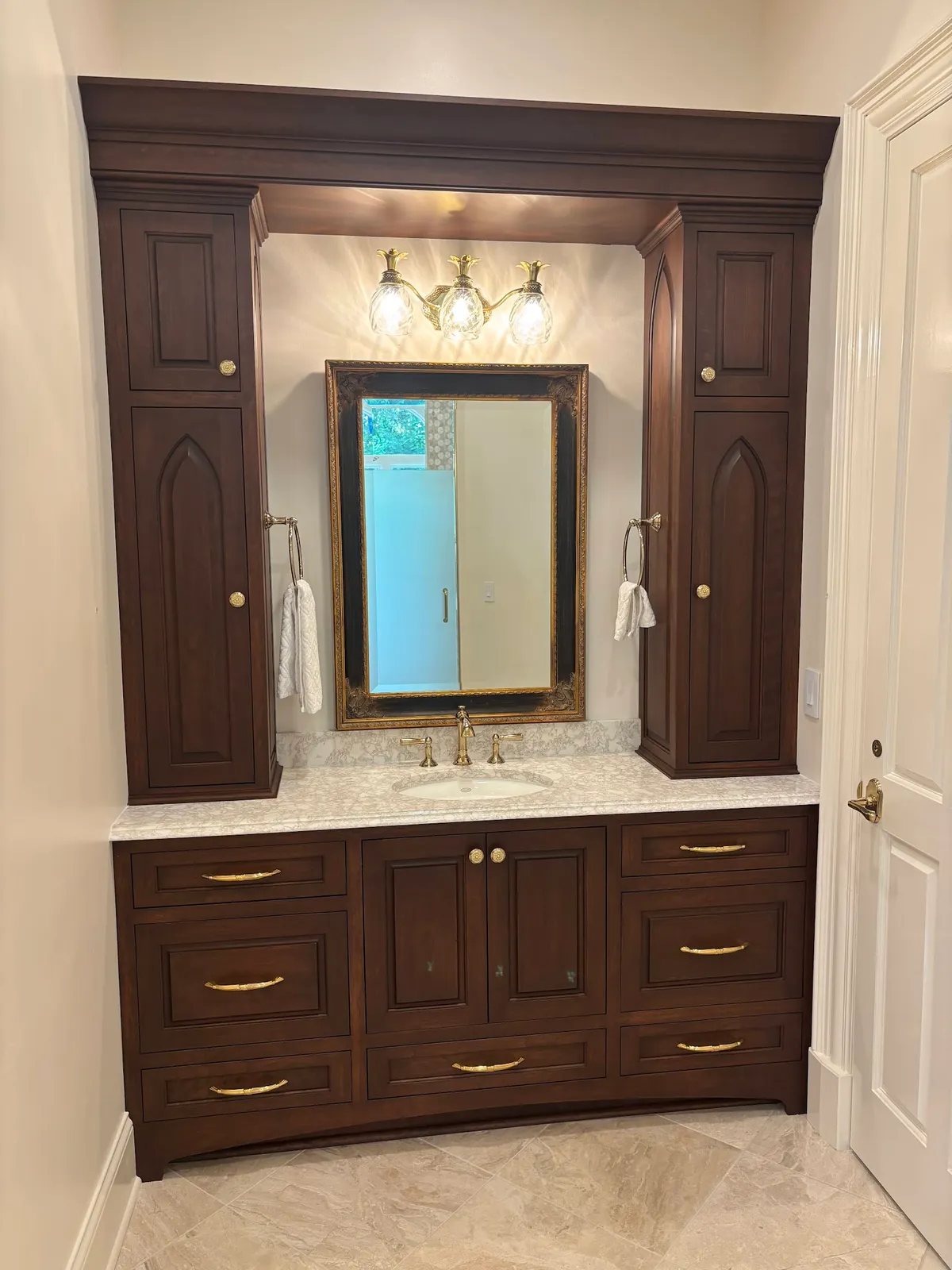 Dark walnut bathroom vanity with double mirror and brass pendant lighting
