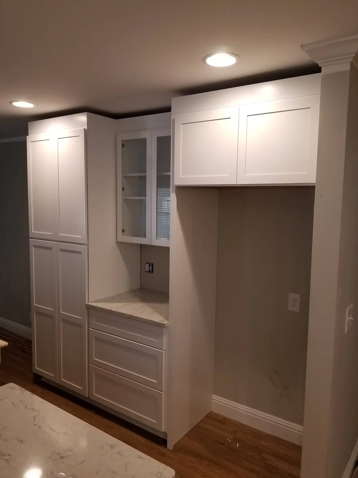 White shaker closet cabinets with glass doors and quartz countertop