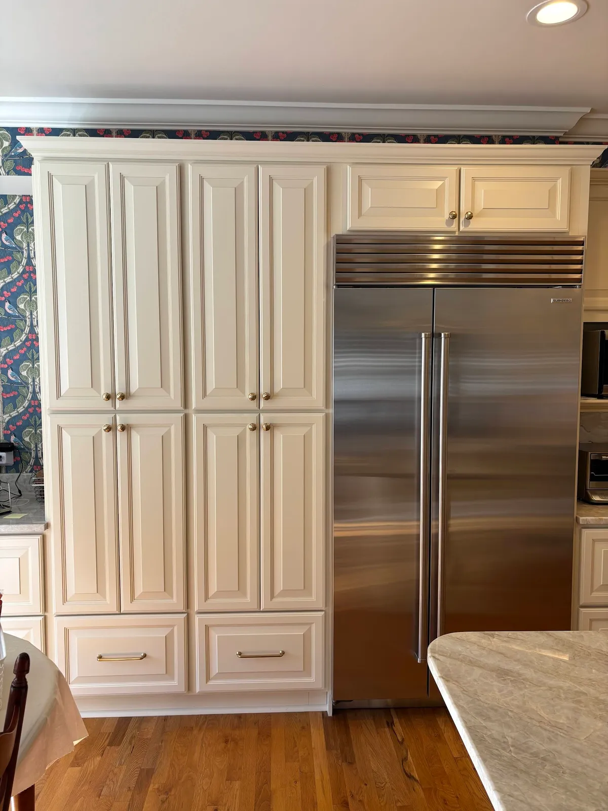Cream shaker kitchen with stainless refrigerator tower and brass hardware