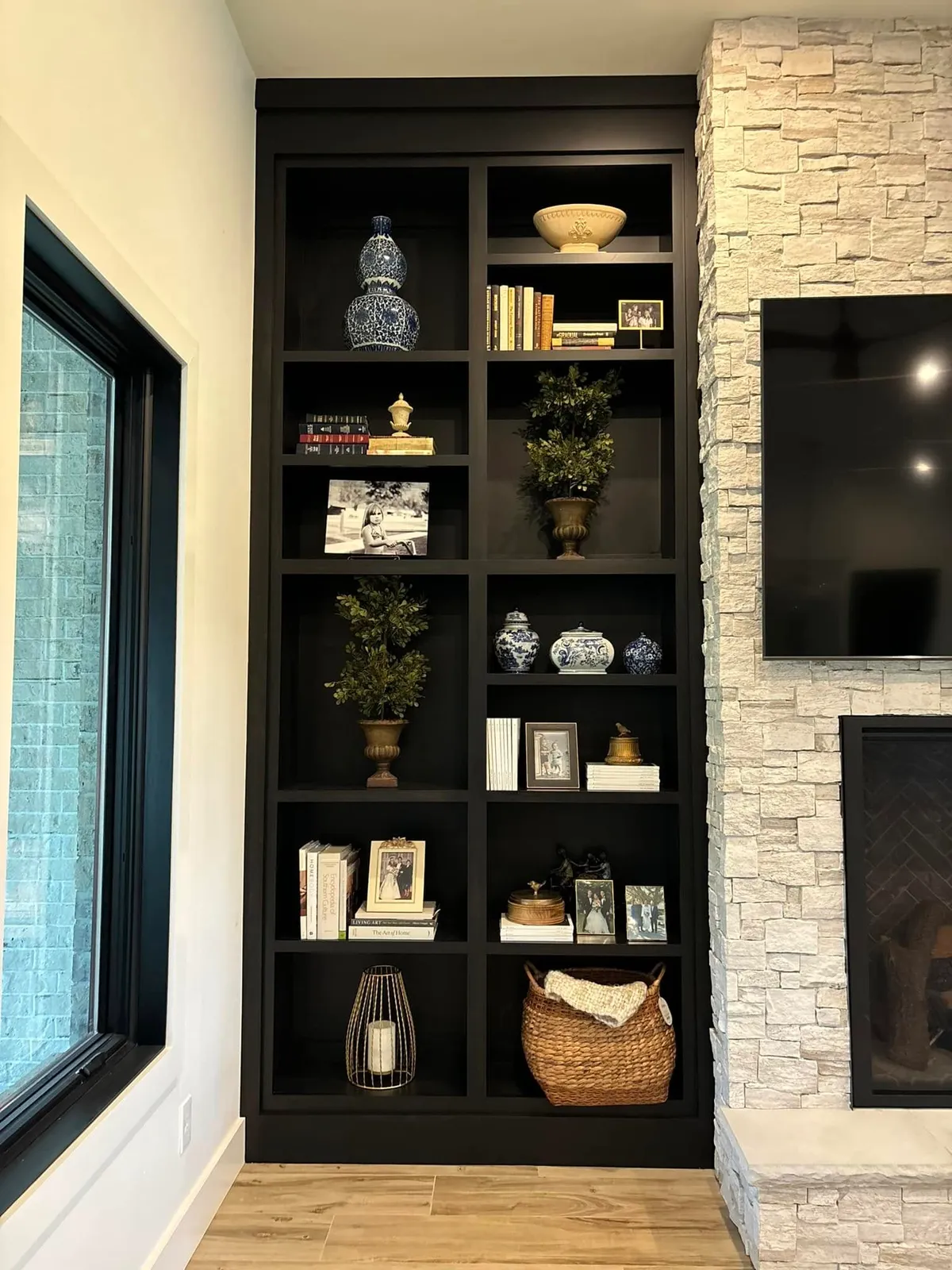 Black built-in shelving unit with LED lighting and decorative display