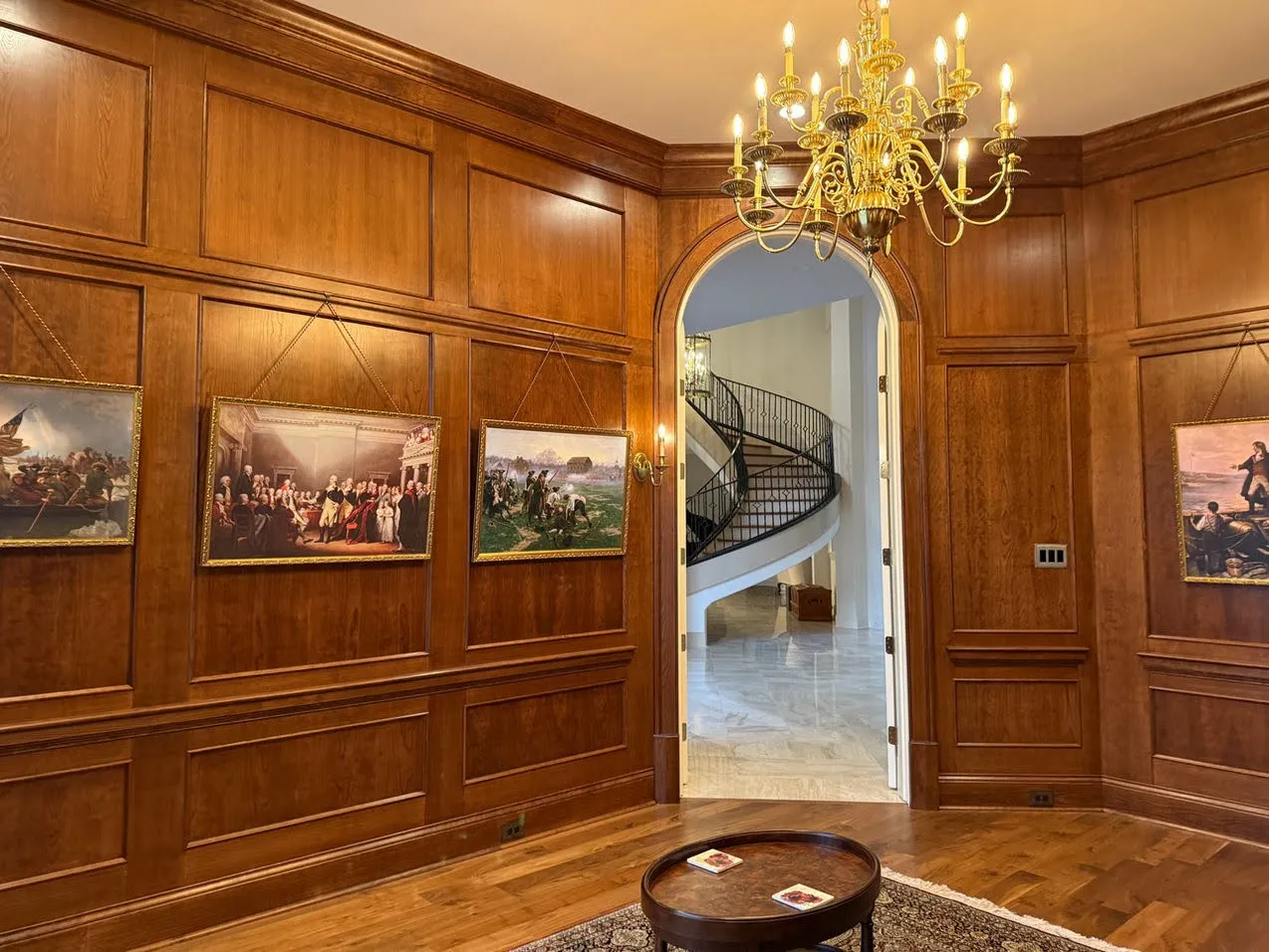 Formal walnut library with wood paneling and gold-framed artwork
