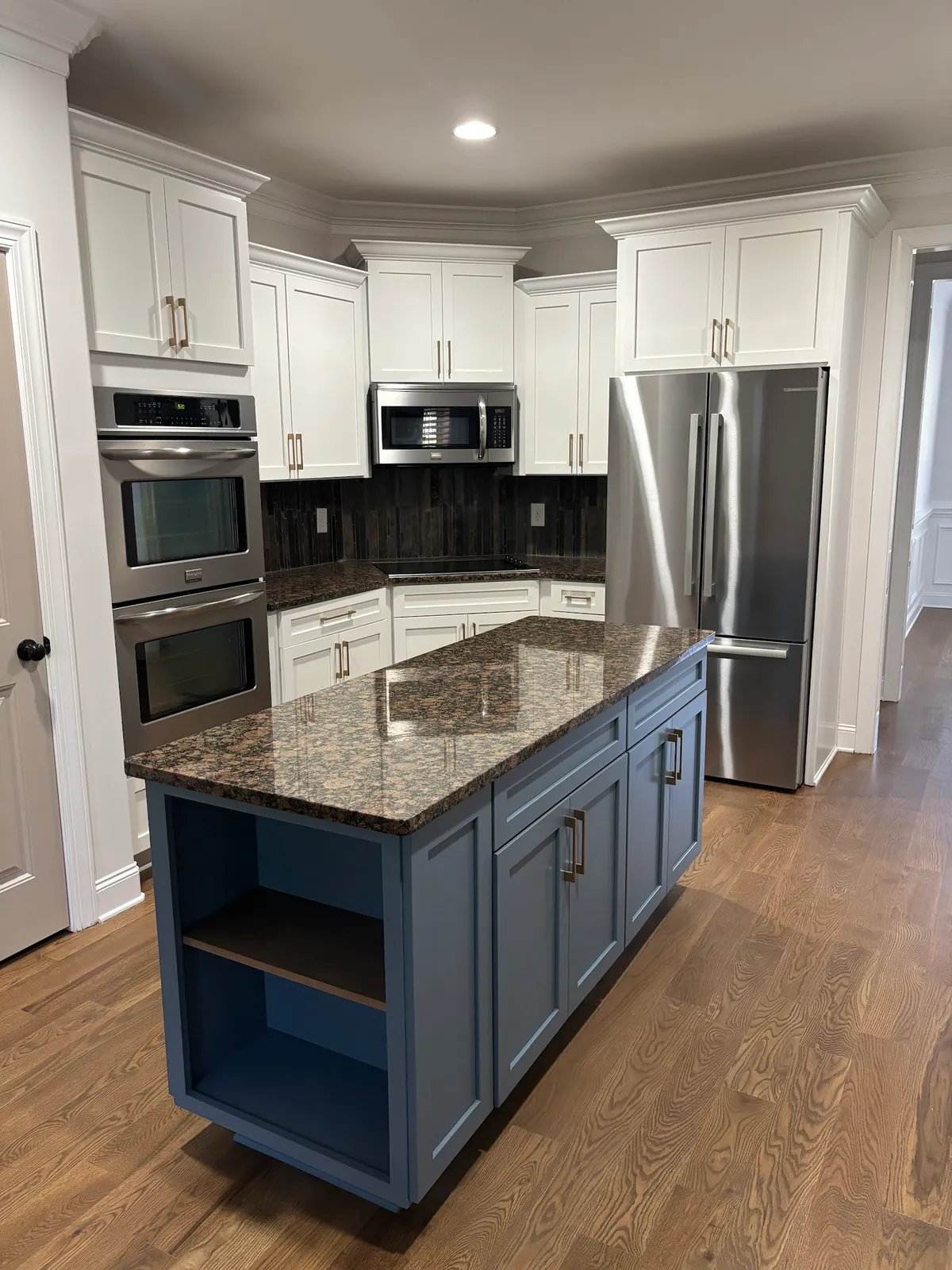 White and blue kitchen island with granite top and stainless appliances