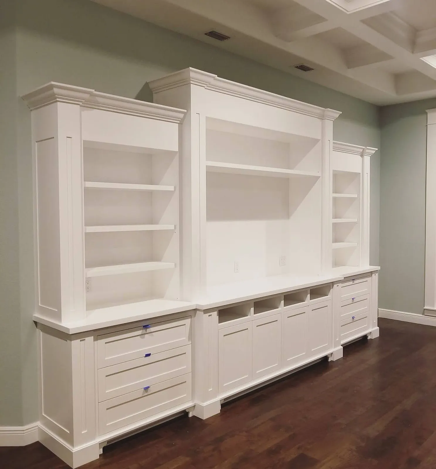 White entertainment wall with open shelving and lower cabinetry storage