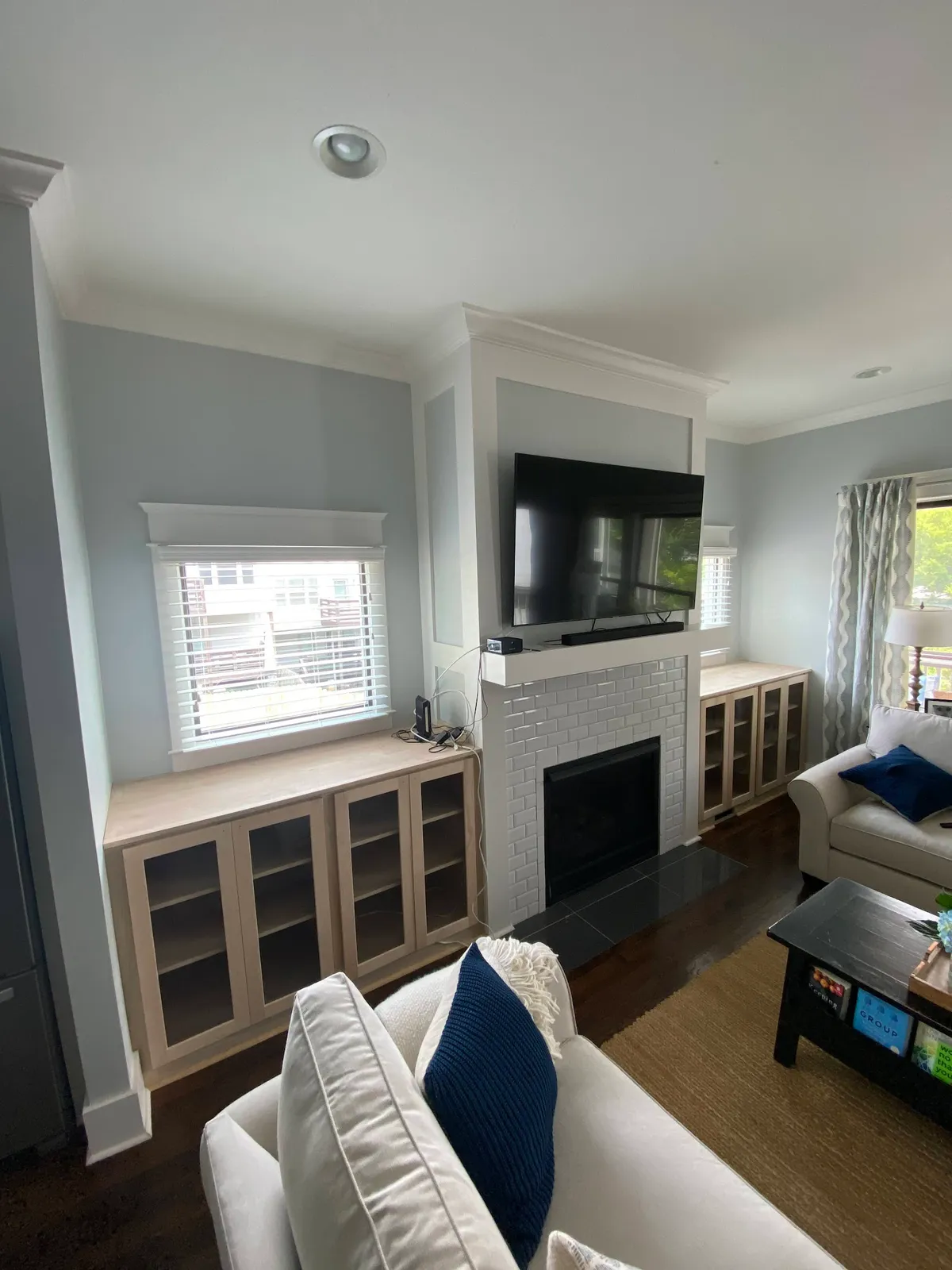 Light wood living room storage with window benches and fireplace wall