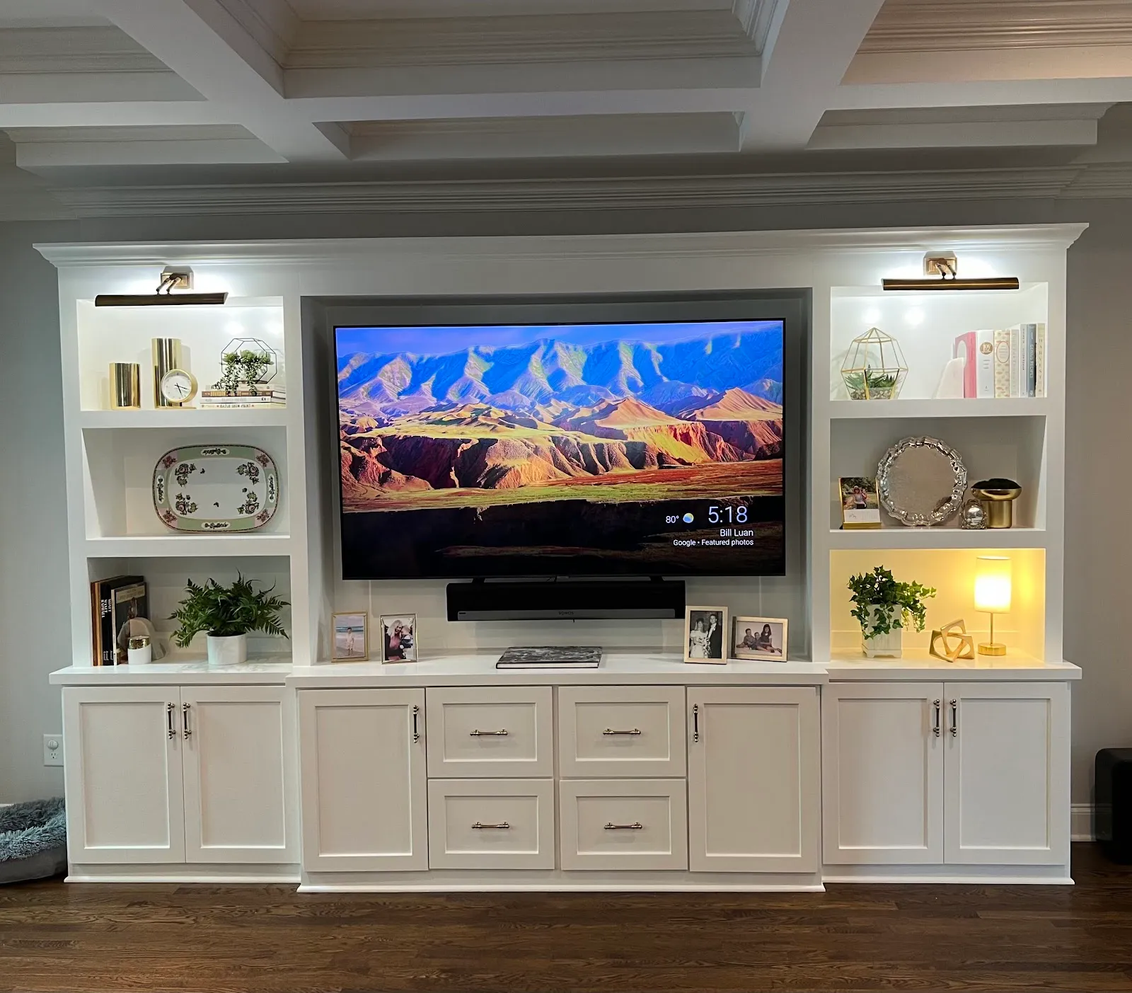 Large white entertainment center with open shelving and glass-front cabinetry