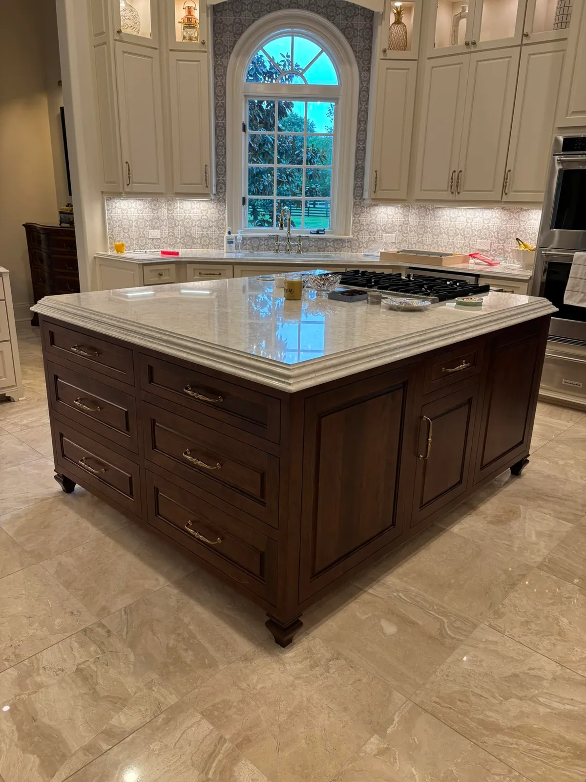 Elegant kitchen island with dark wood base and white marble countertop