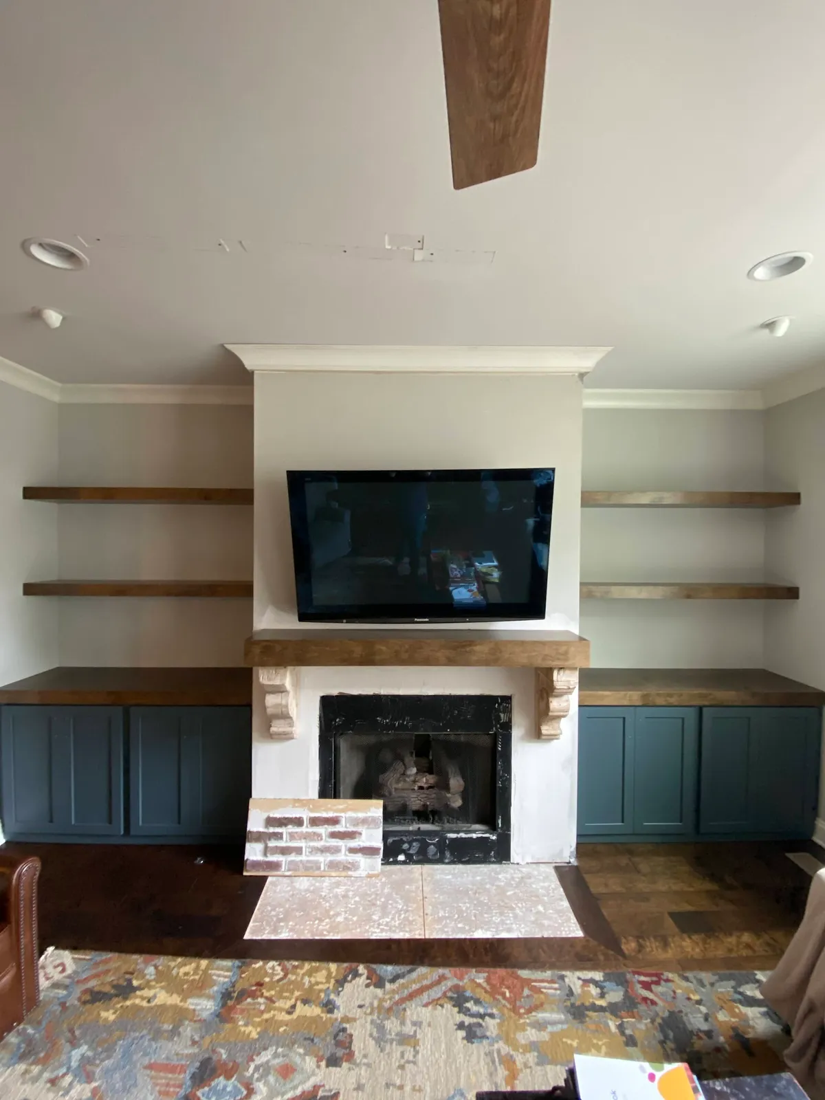 Fireplace mantel with white surround and dark wood floating shelves