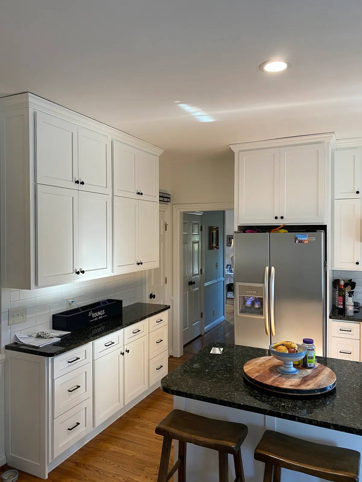 White kitchen with black countertop island and stainless steel appliances