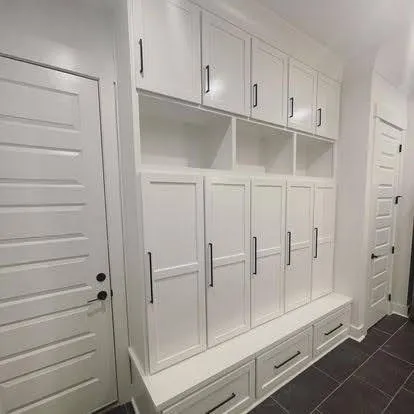 White mudroom cabinetry with glass-front upper doors and lower storage