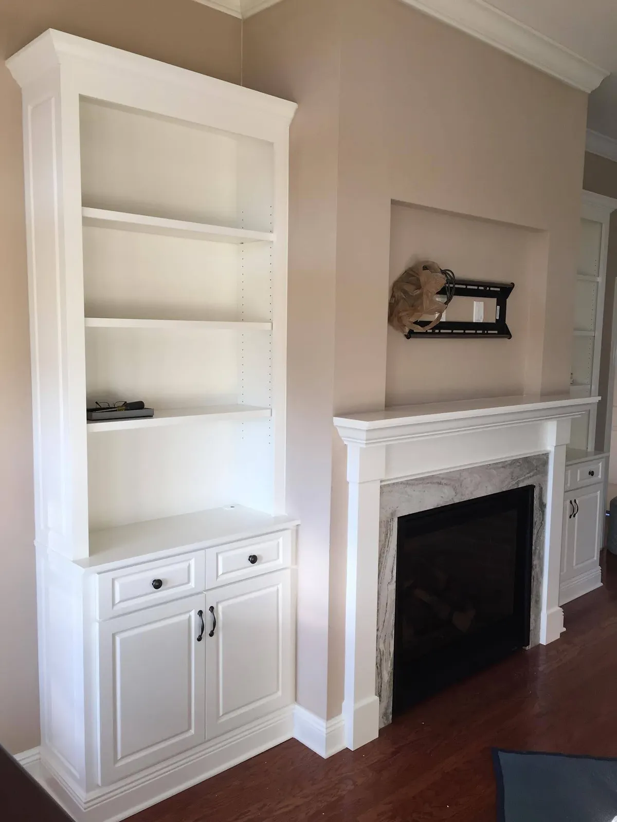 White built-in bookcase with open shelving and lower cabinet doors
