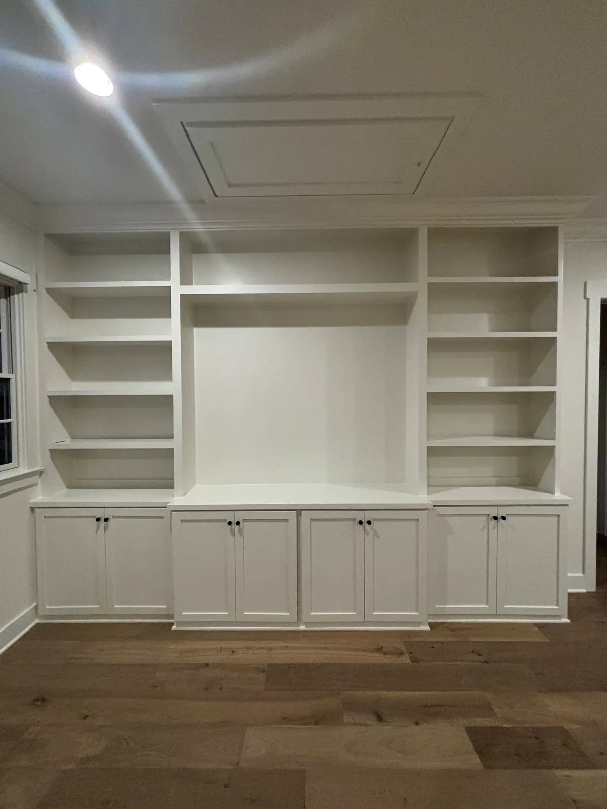 White built-in display wall unit with center opening and lower doors