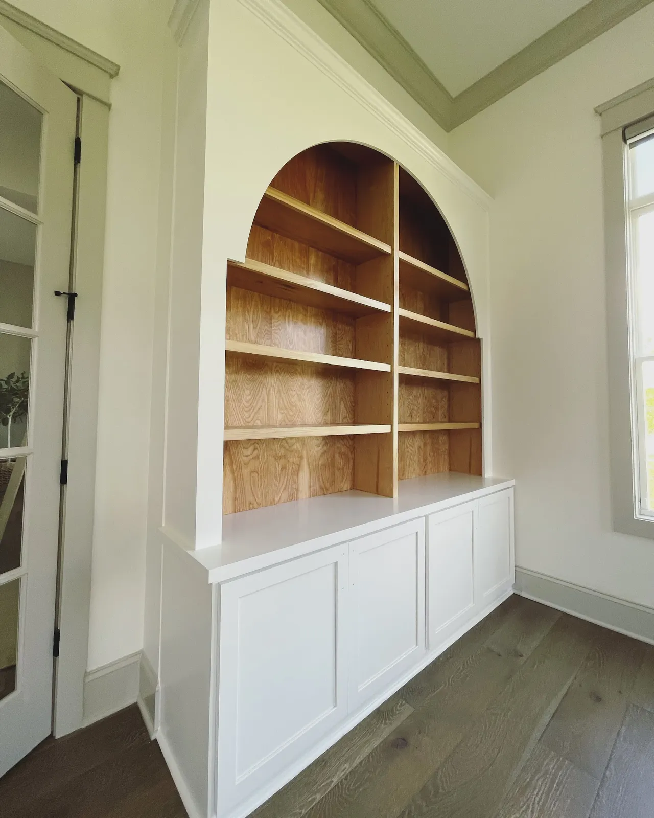 White fireplace mantle with wood-backed arched bookcase built-in