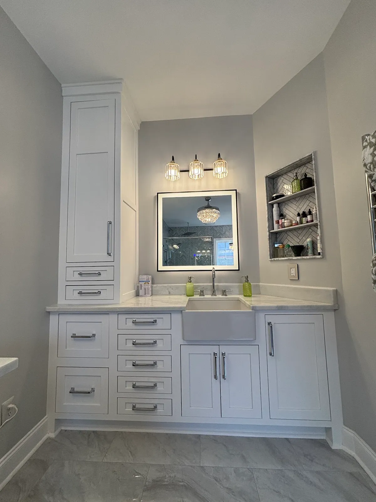 White bathroom vanity with black sink, marble countertop and sconce lighting
