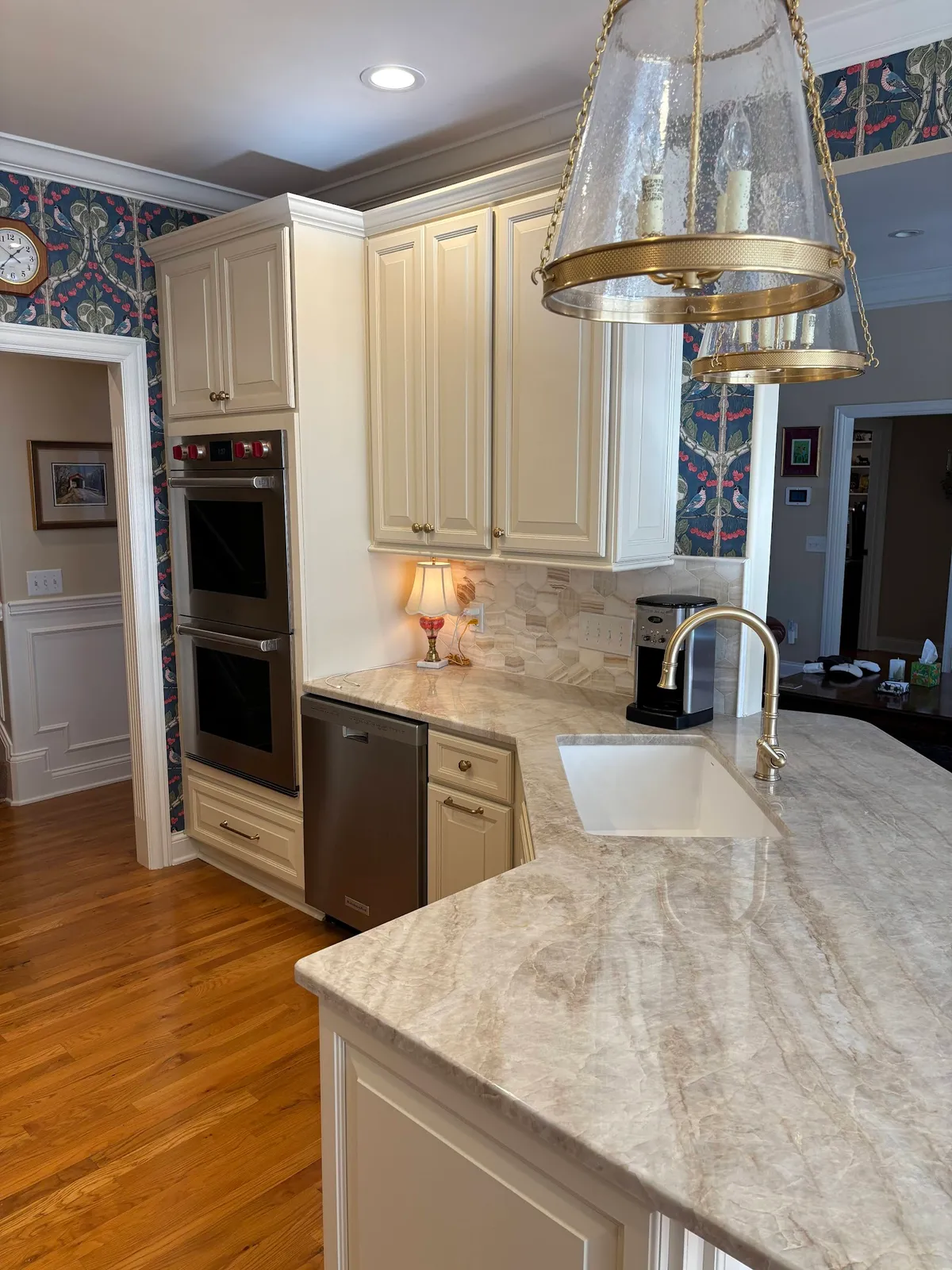 Cream kitchen with dual islands, glass pendant lights and marble counters