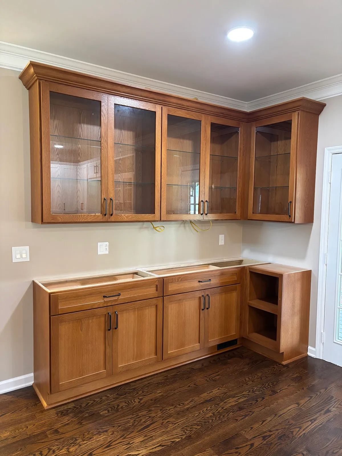 Honey oak cabinetry with glass-front uppers, wood countertops and open shelving