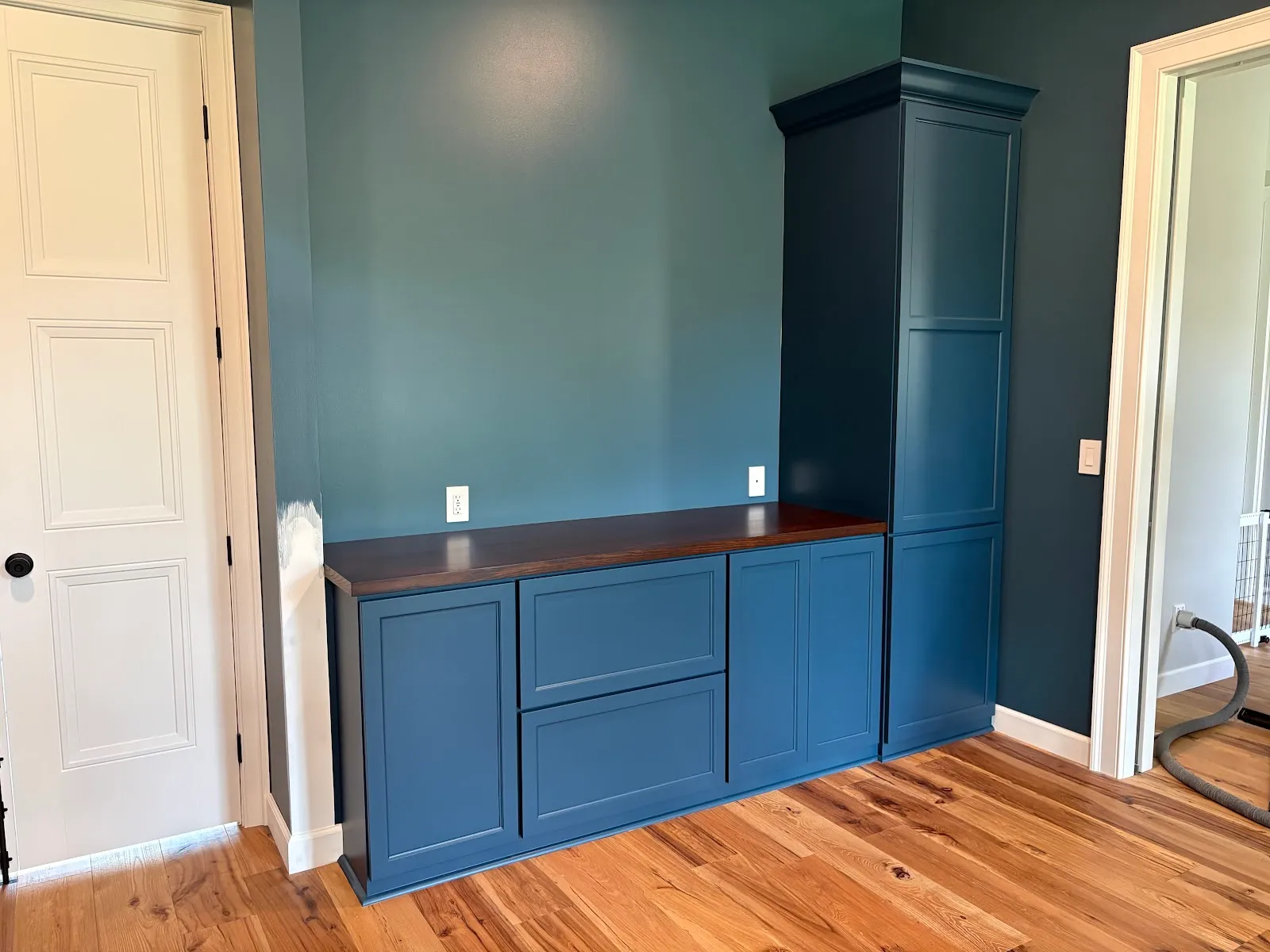Blue painted cabinetry with walnut countertop and dark island accent