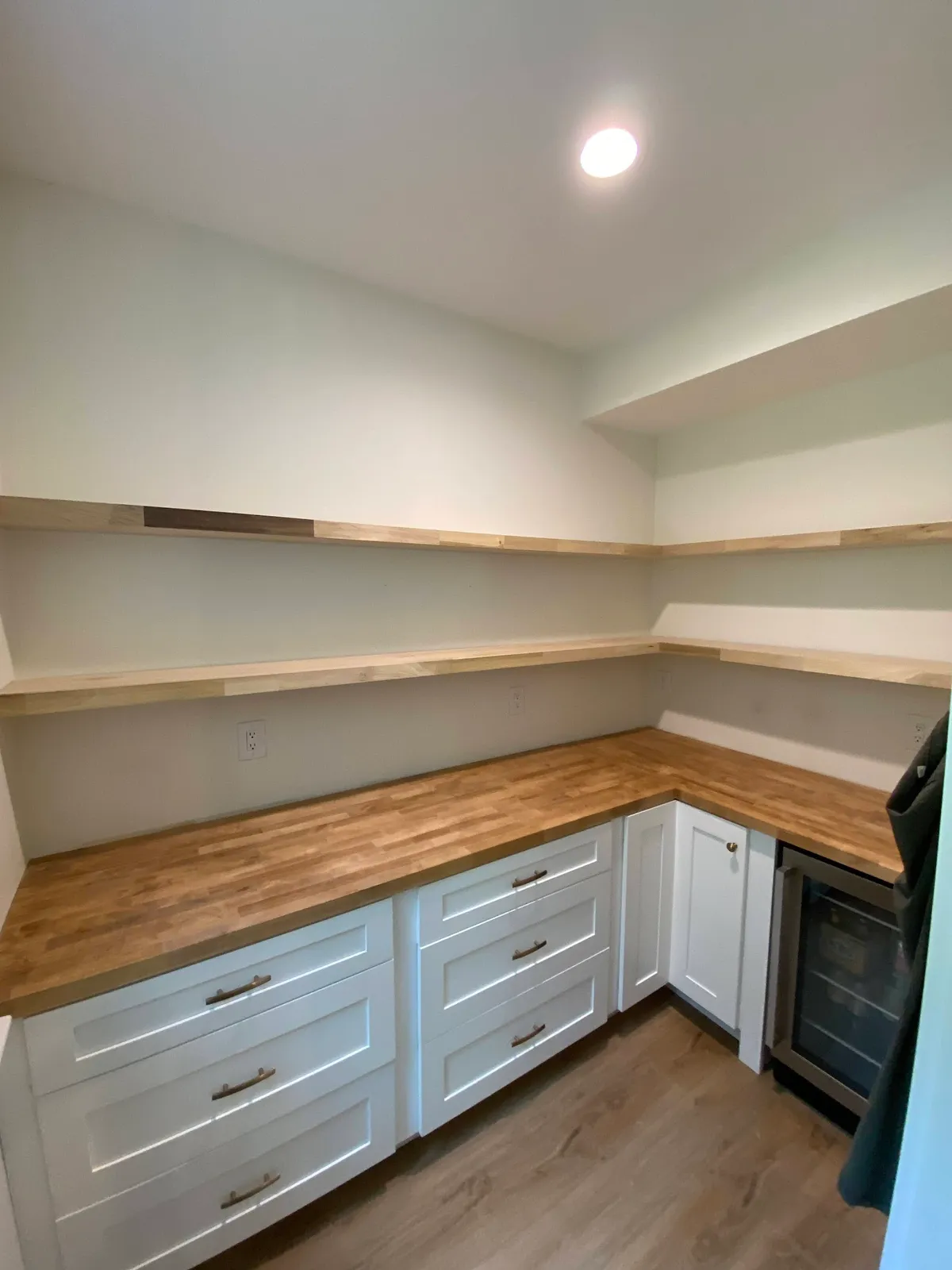 White kitchen pantry with wood shelving, walnut counters and cabinet bases