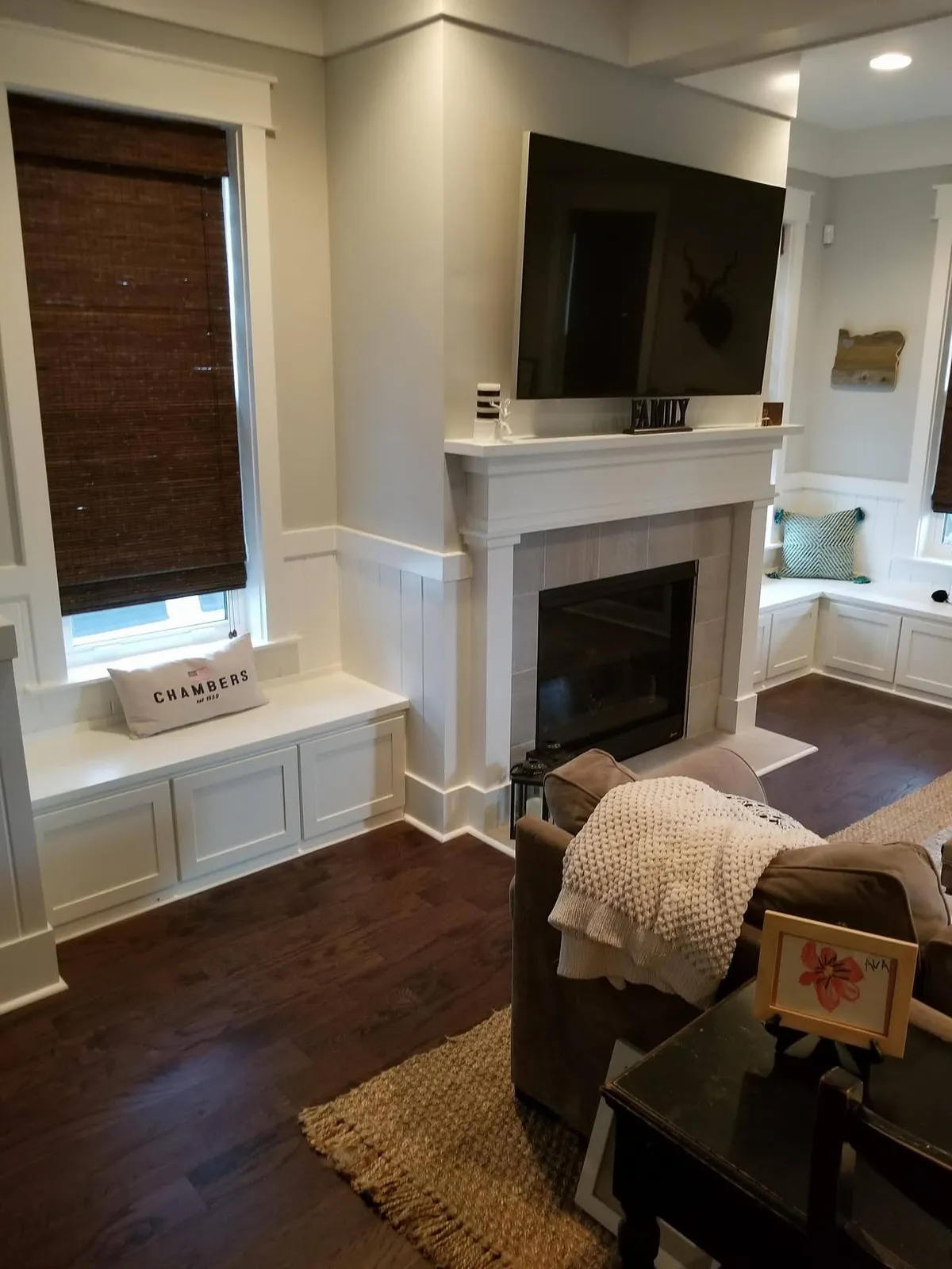 White fireplace mantle with cabinetry and built-in window seat
