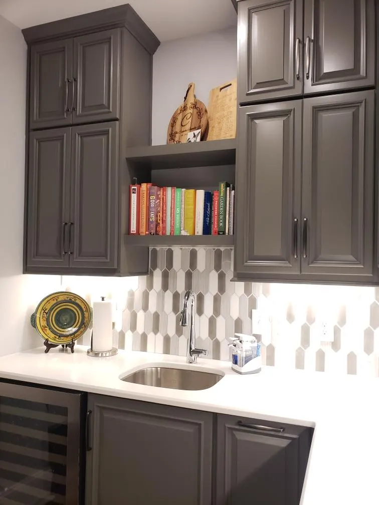 Charcoal gray wet bar with hexagon backsplash and white countertop