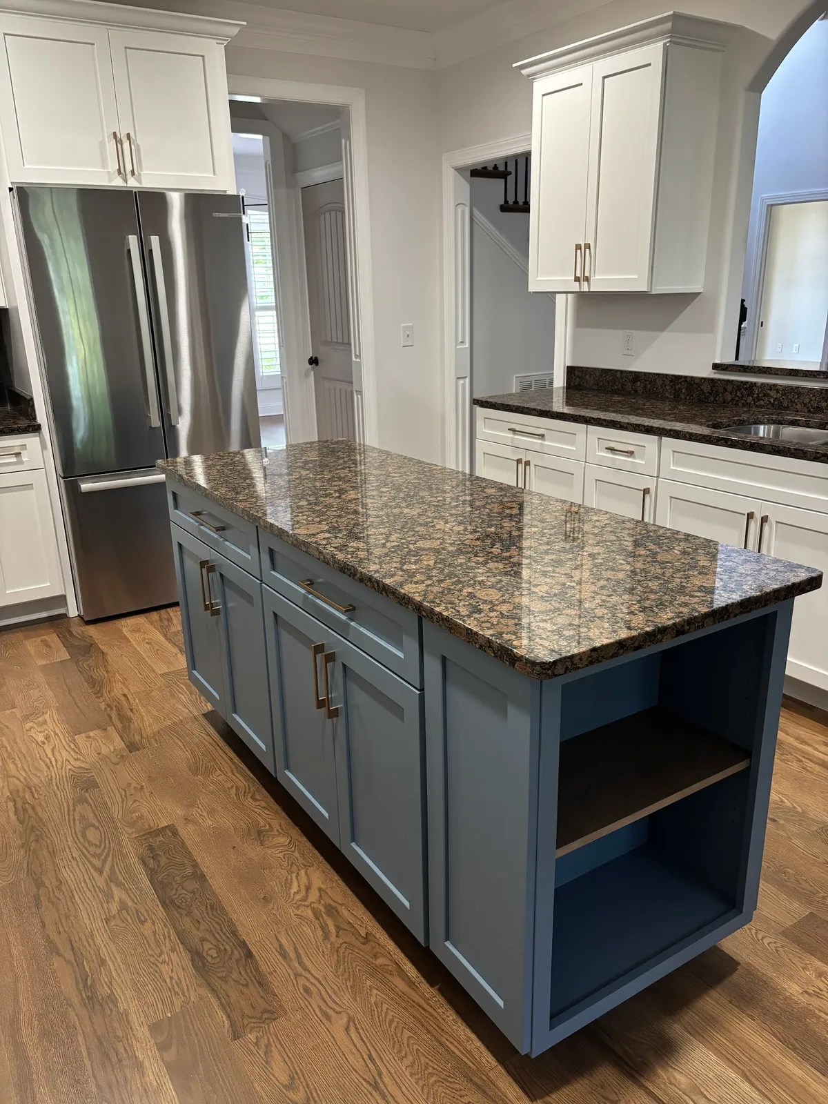 Transitional kitchen with white cabinetry, blue-gray island and granite counters