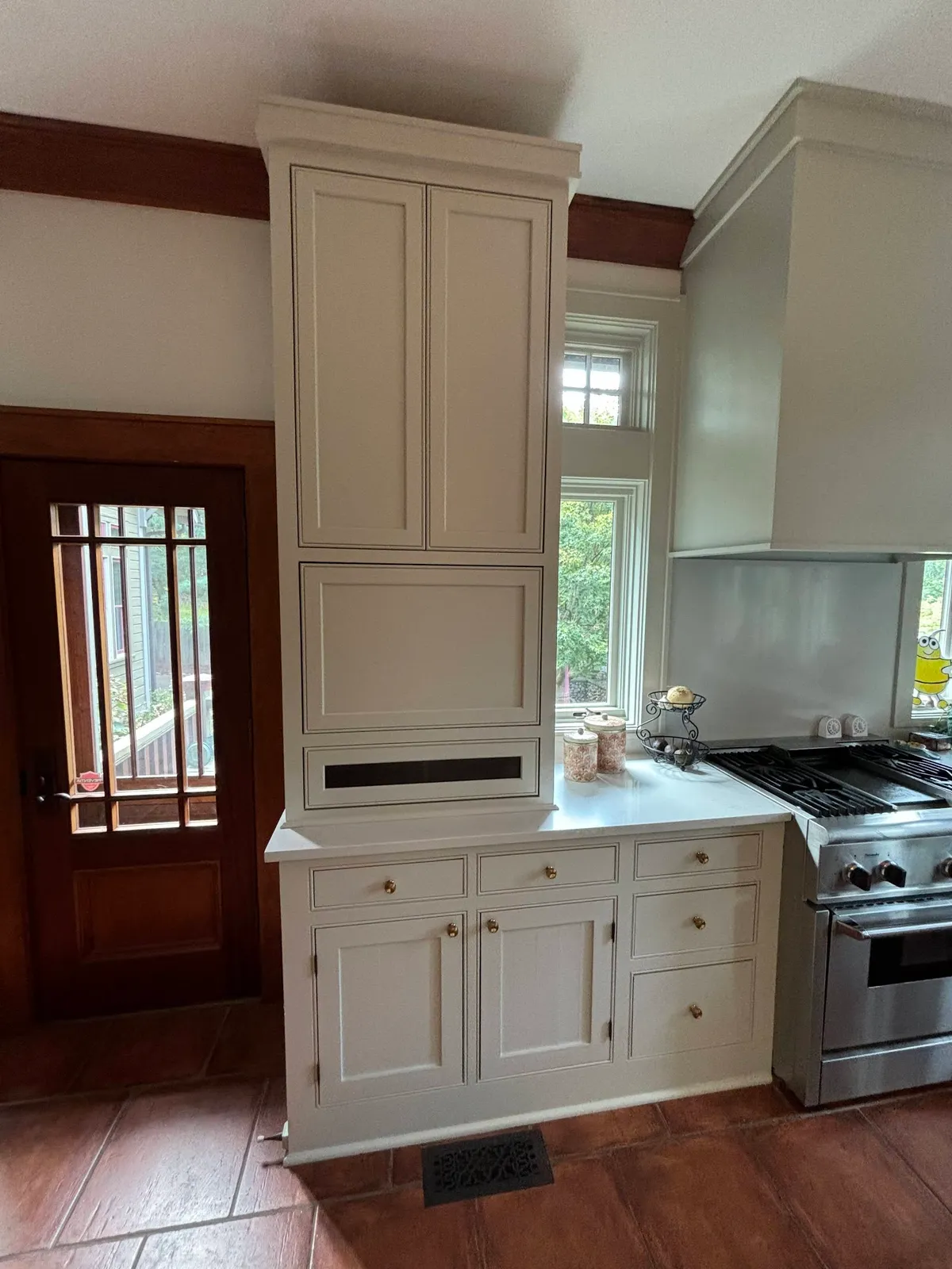 Cream painted kitchen pantry cabinet with upper oven and open shelving