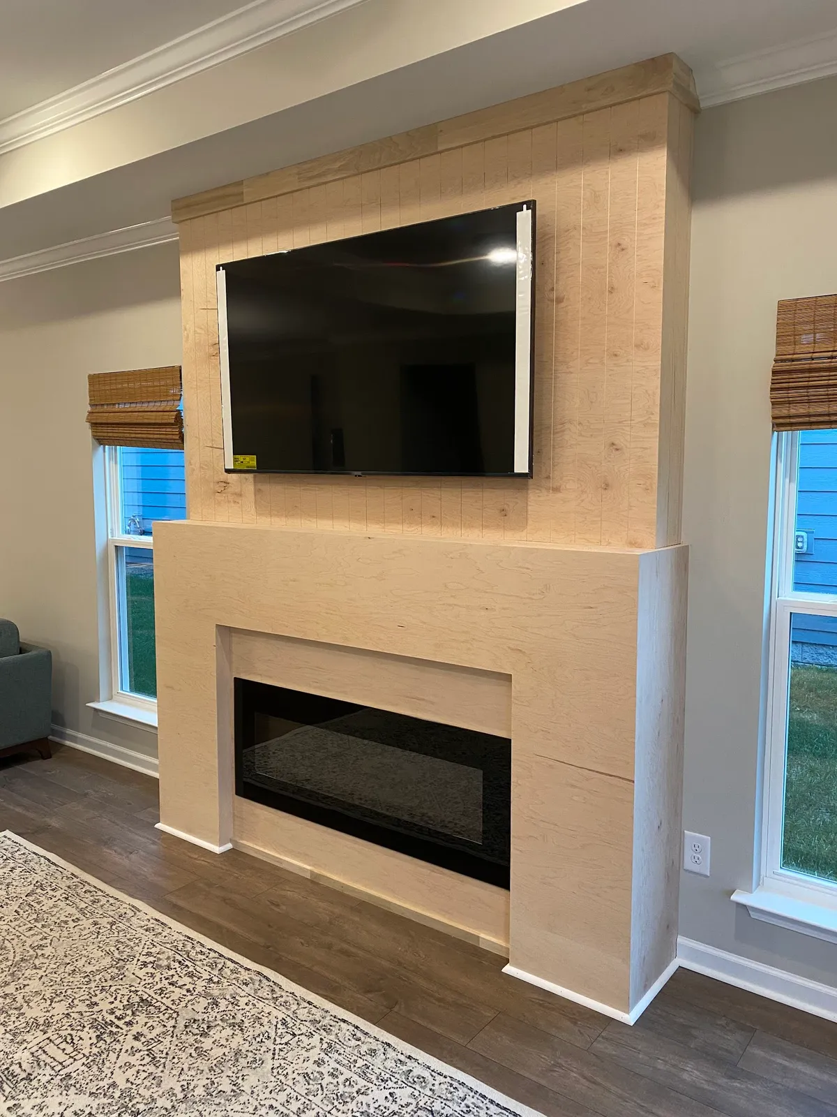 Light wood fireplace mantel built-in with TV mount and shiplap surround