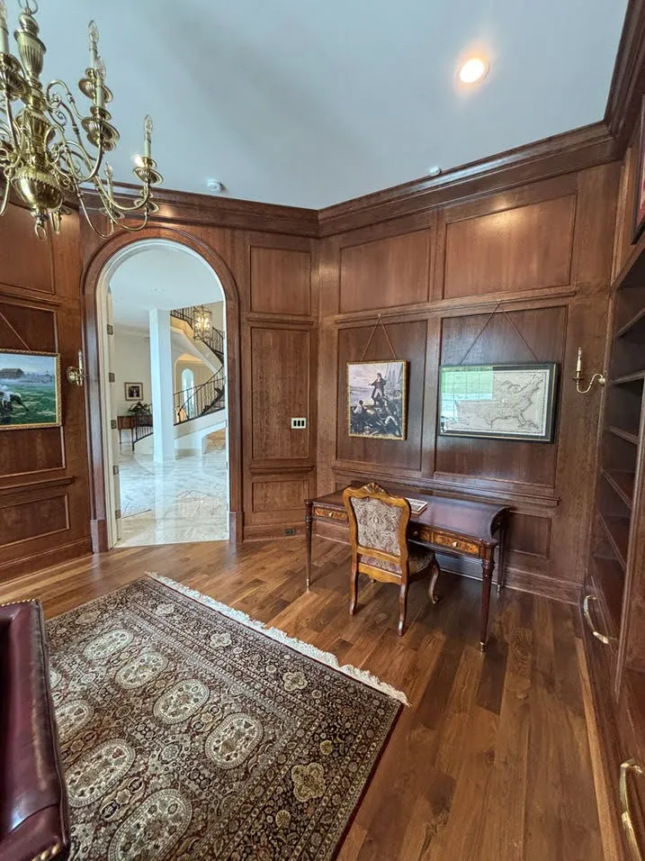 Wood-paneled home office with round mirror door entrance and stain finishes