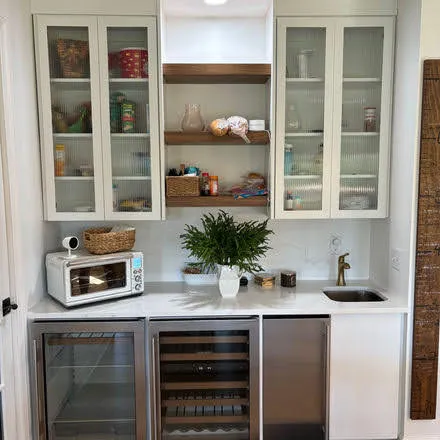 Kitchen beverage bar with white cabinetry, glass doors and wine cooler